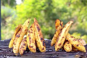 Bole, Nigerian street food, showcasing roasted plantains with grilled fish and spicy pepper sauce