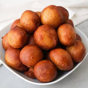 Puff-Puff, a must-try Nigerian street food, consisting of sweet, fluffy dough balls, deep-fried to golden perfection