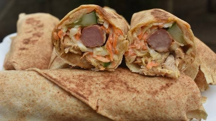 Shawarma, a must-try Nigerian street food, with spiced meat wrapped in flatbread, enriched with vegetables and sauces