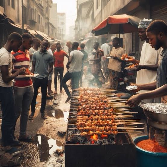 A bustling Nigerian street scene featuring the preparation of Suya, a must-try Nigerian street food. Skewers of spiced meat are grilled over an open flame, capturing the essence of Nigeria’s vibrant street food culture